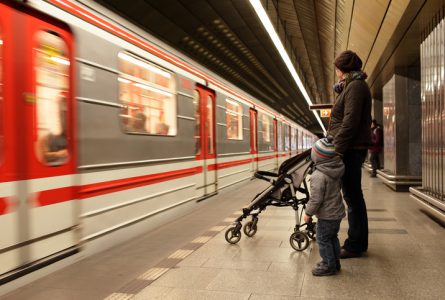 Family looking at train at subway station in Prague